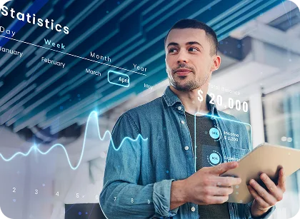 A man in a denim shirt holds a tablet while futuristic data charts and a line graph float around him, suggesting analytics work.