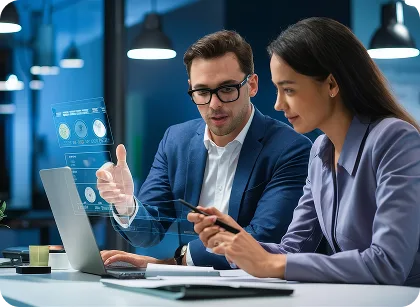 Two professionals collaborate at a desk, examining data on a laptop with a holographic dashboard.