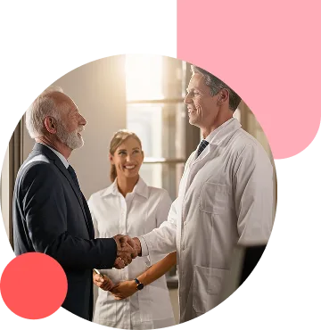 Two men in business attire shake hands in a professional setting, as a smiling woman in a white coat stands behind them.
