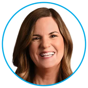 Close-up portrait of a smiling woman with brown hair against a white background, inside a blue circular frame.