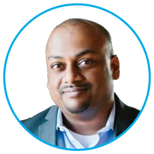 Profile portrait of a smiling man in a blue blazer and light shirt, within a circular blue-bordered avatar.