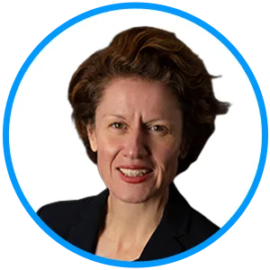 Head-and-shoulders portrait of a smiling woman with short brown hair wearing a dark blazer against a white background.