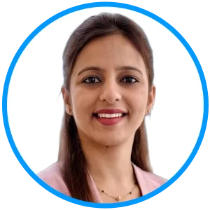 Portrait of a smiling professional woman with dark hair, wearing a pink blazer, inside a circular blue-bordered frame against a white background.